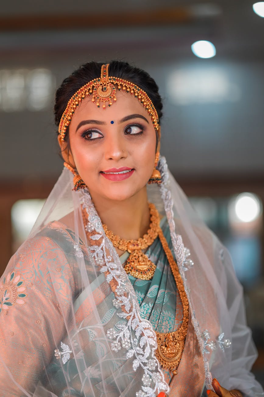 A beautiful Indian bride adorned in traditional attire, featuring intricate jewelry and a graceful pose. [pexels]