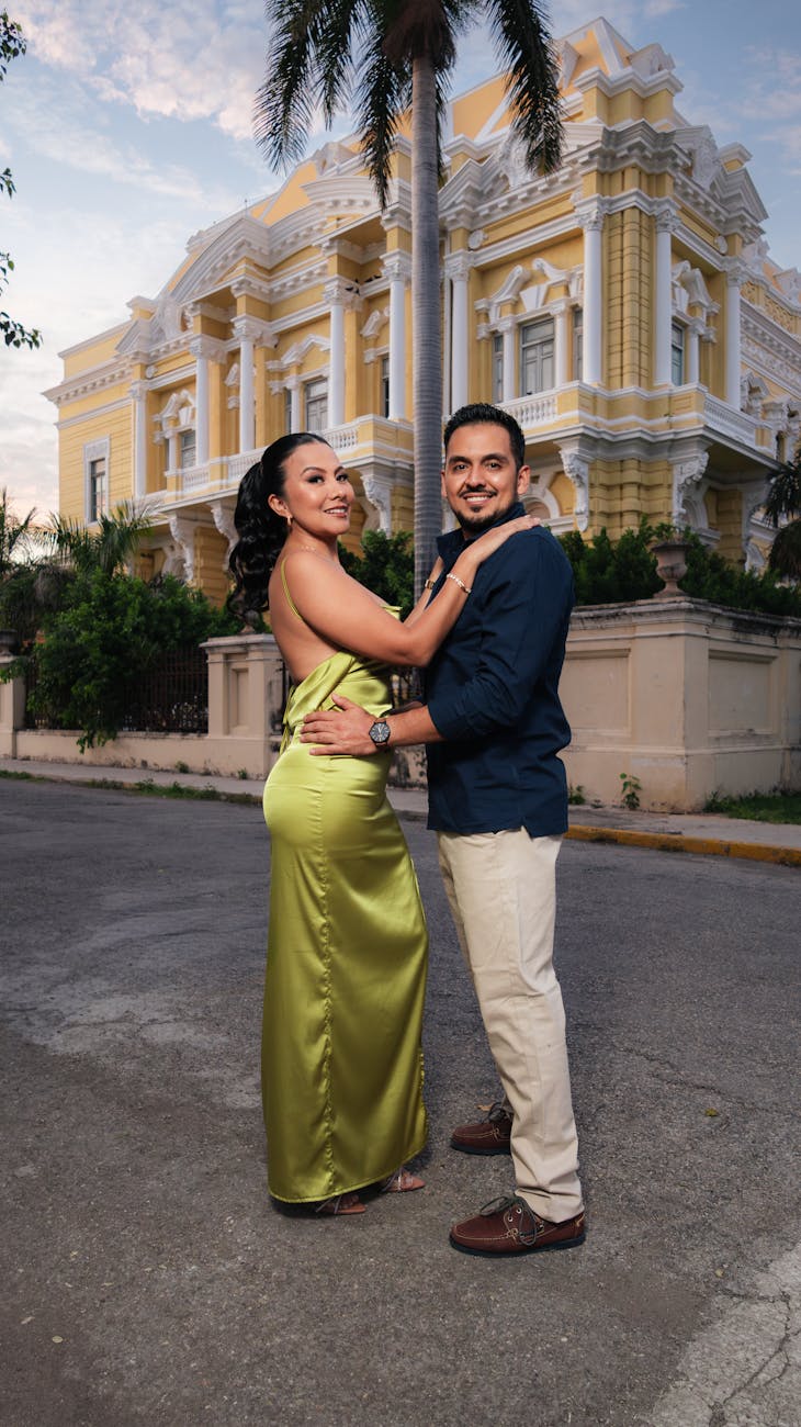Elegant couple standing in front of a historical mansion during twilight, capturing romance and style. [pexels]